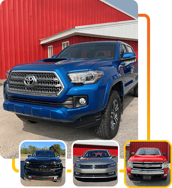 a blue toyota tacoma truck is parked in front of a red barn .