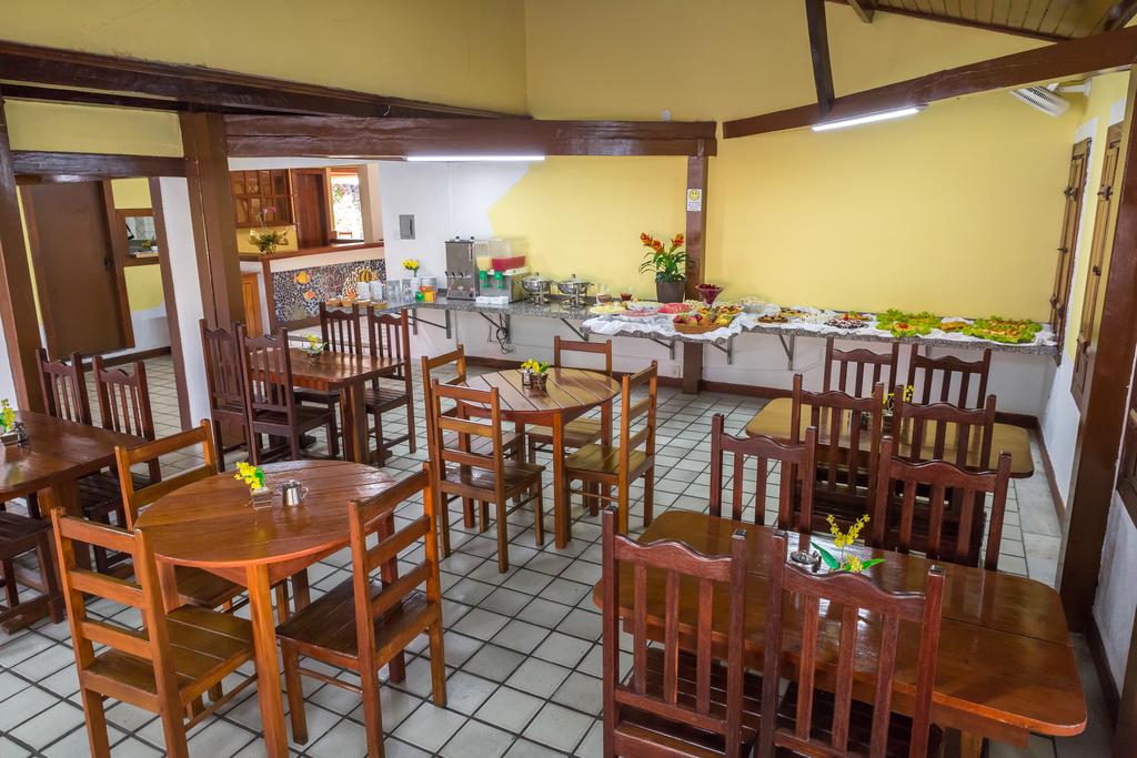 Um restaurante com mesas e cadeiras e buffet.