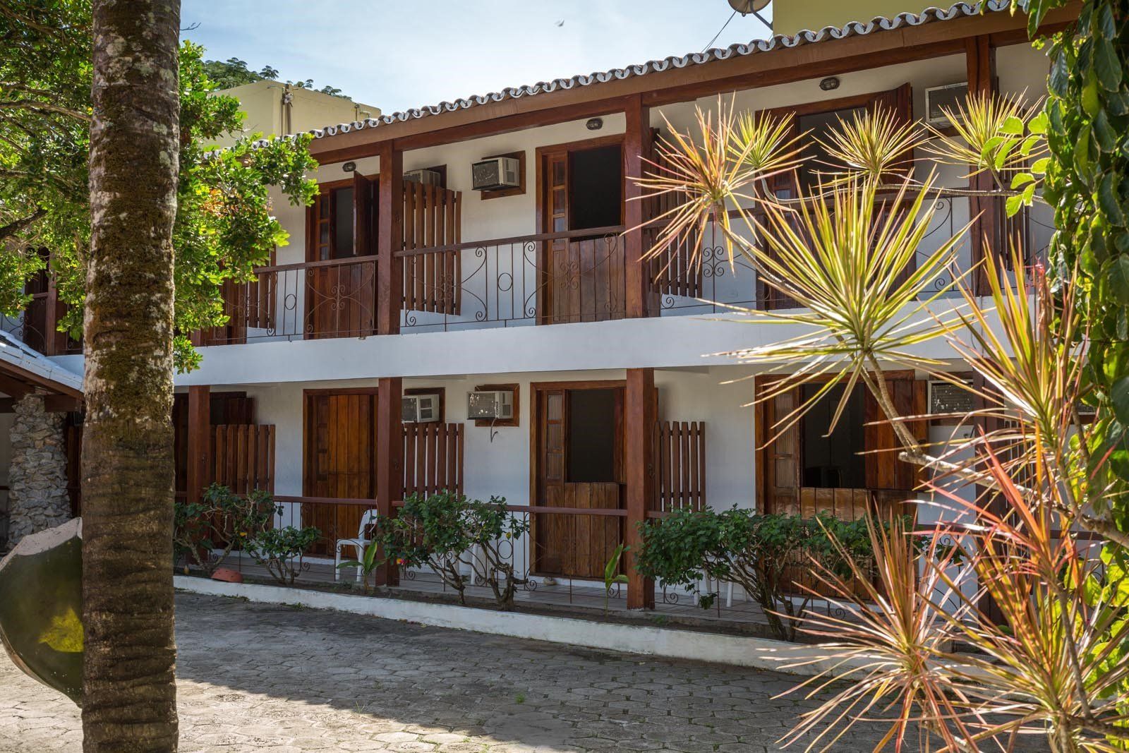 Um prédio com muitas janelas e uma palmeira na frente.