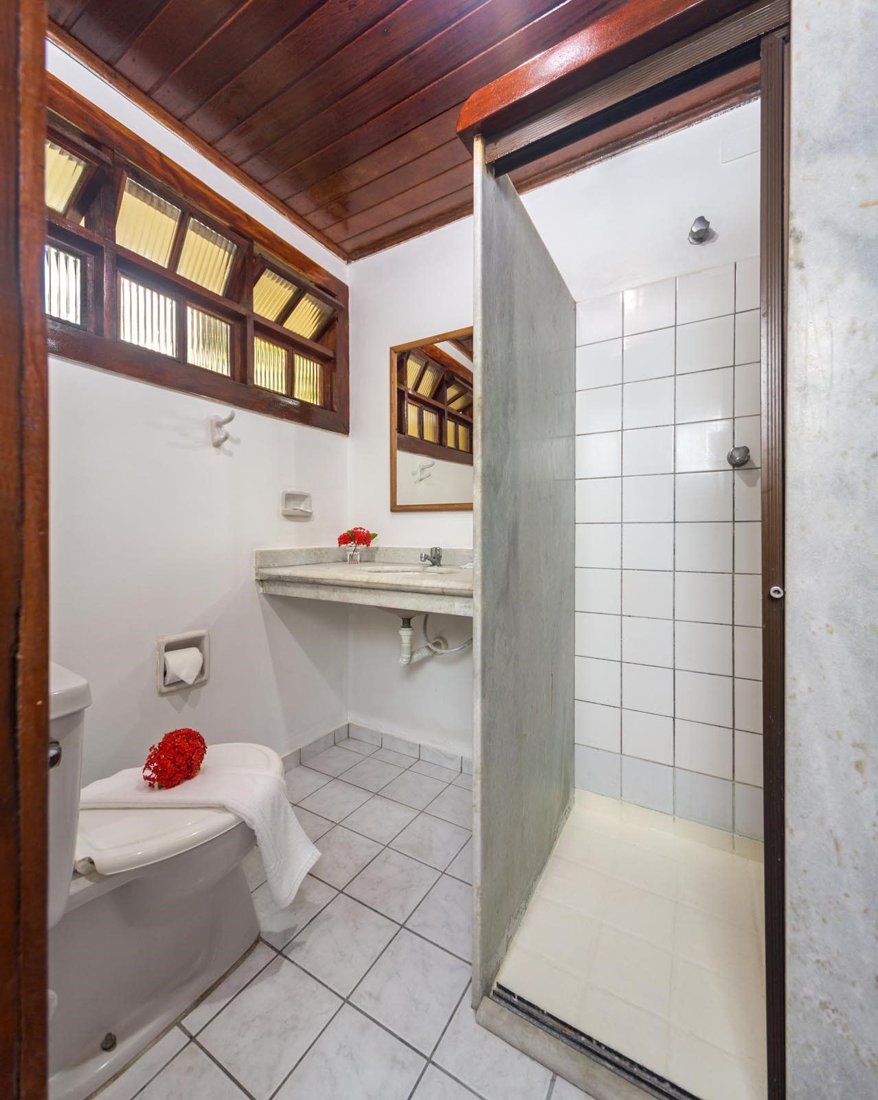 Um banheiro com vaso sanitário, pia e chuveiro