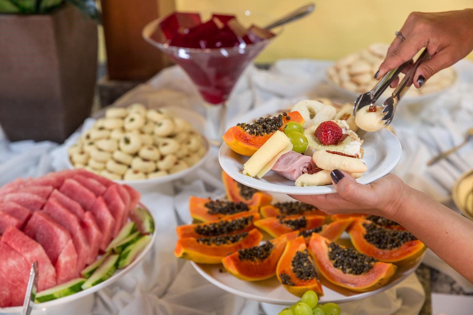Uma pessoa está segurando um prato de frutas sobre uma mesa.