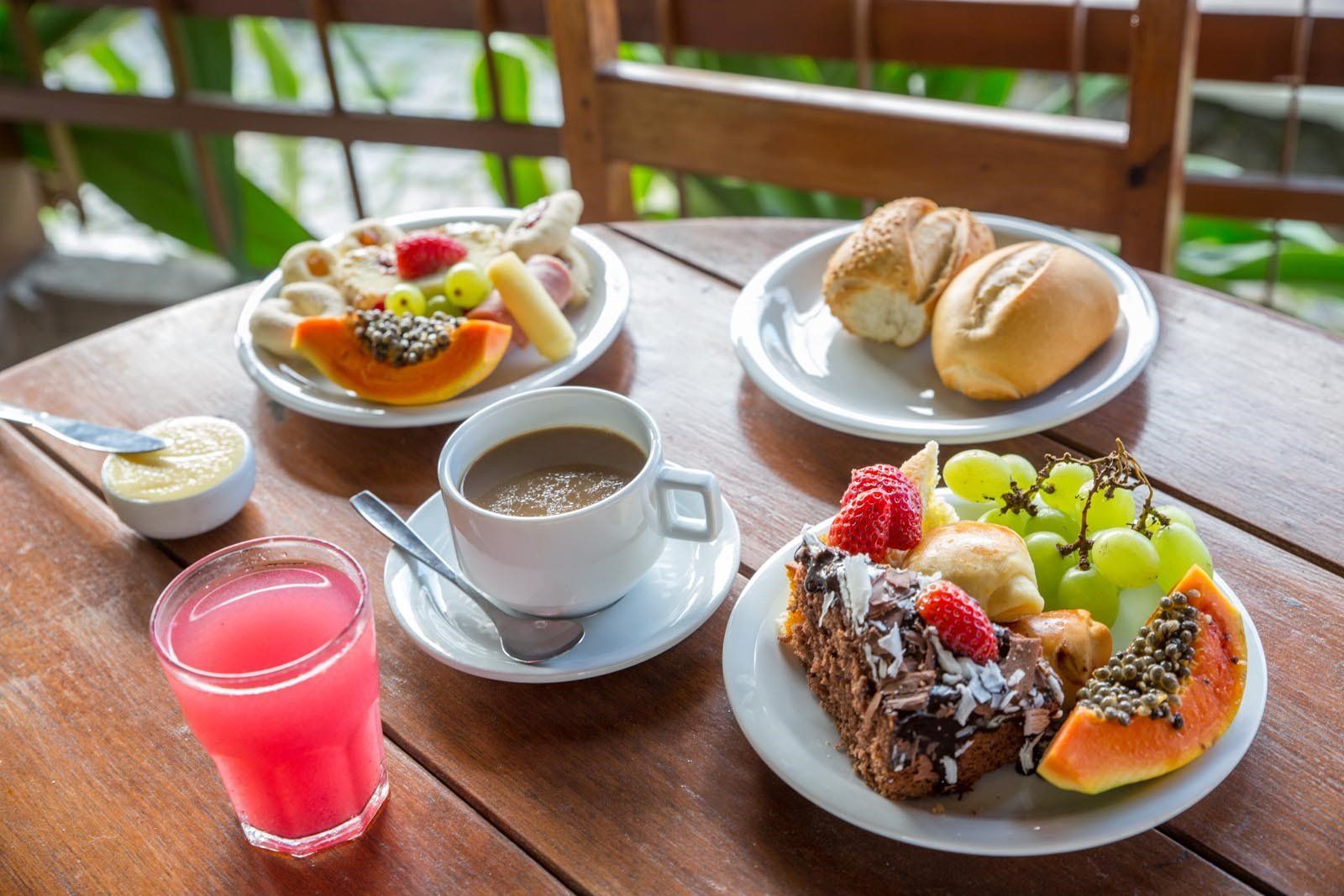 Uma mesa de madeira com pratos de comida e bebidas.
