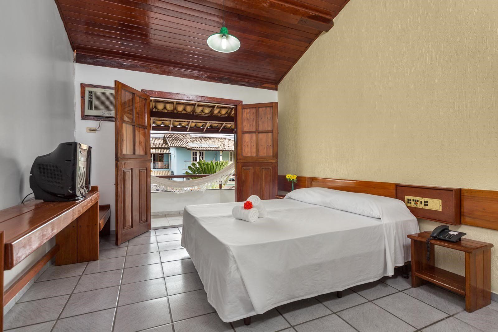 Um quarto de hotel com uma cama grande e uma televisão