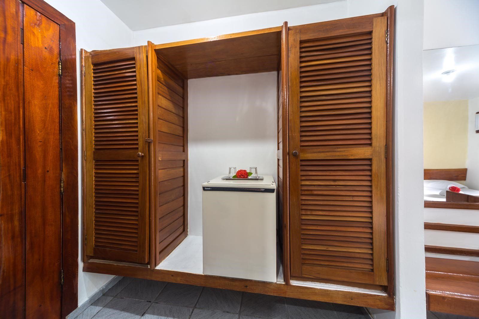 Um quarto com armário e geladeira.