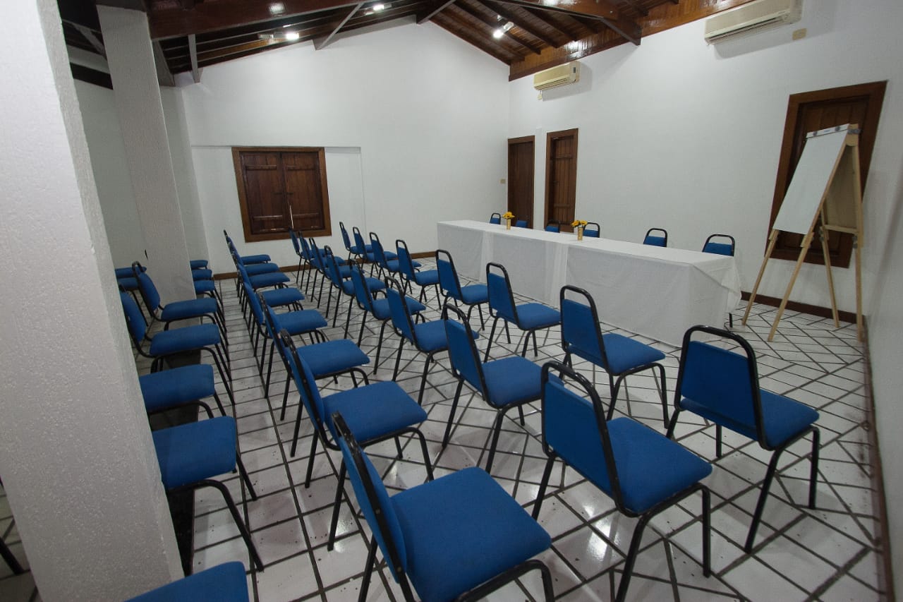 Uma sala de conferências com cadeiras azuis e mesas brancas