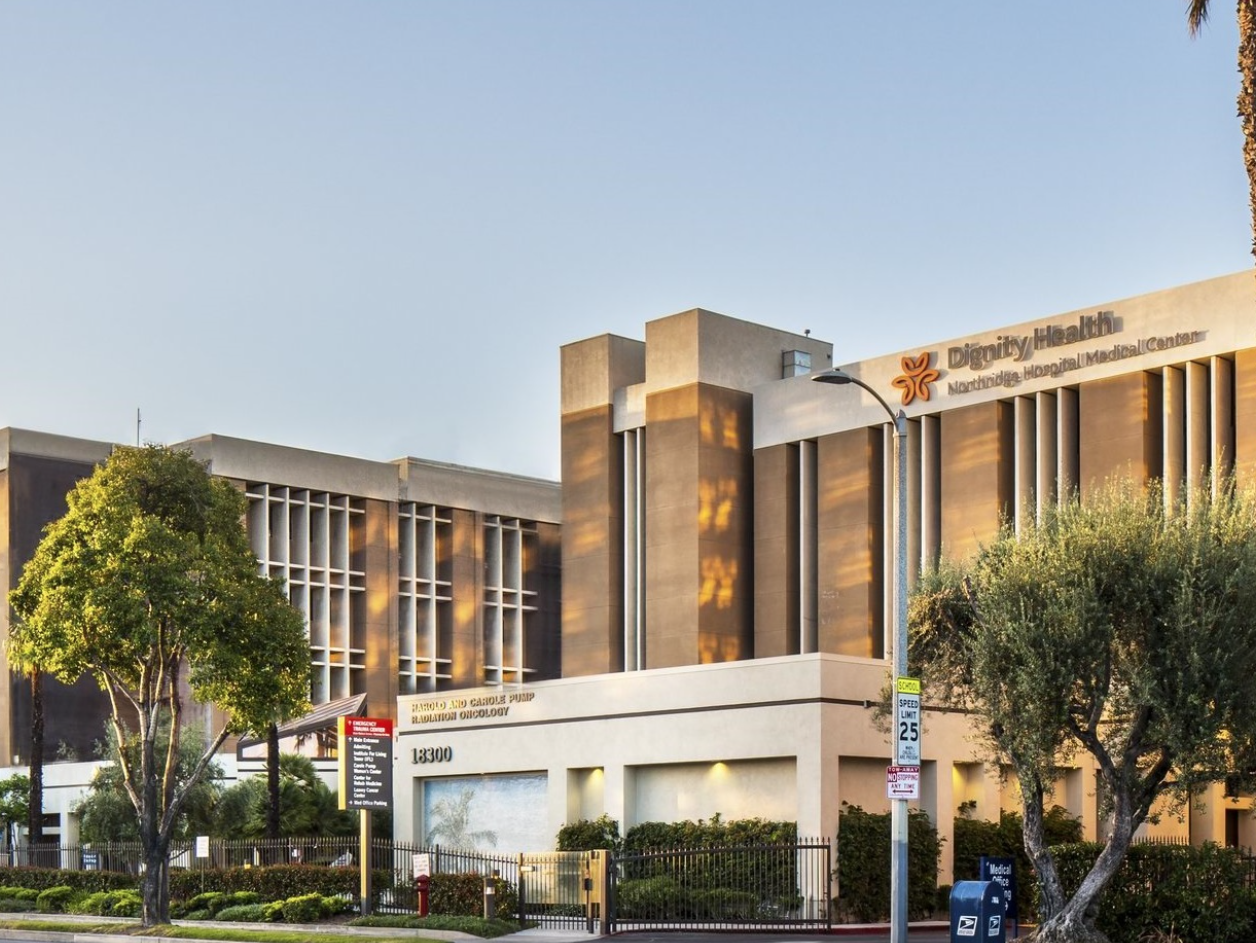 Hospital building, Dignity Health signage, beige and brown facade, trees, sunny day.