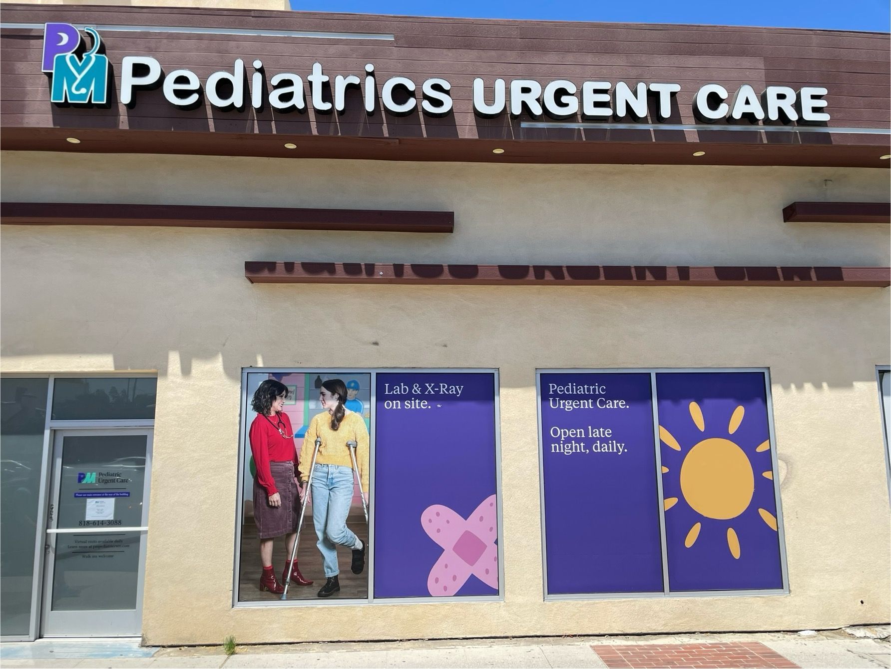 Exterior of a pediatrics urgent care clinic with window posters.