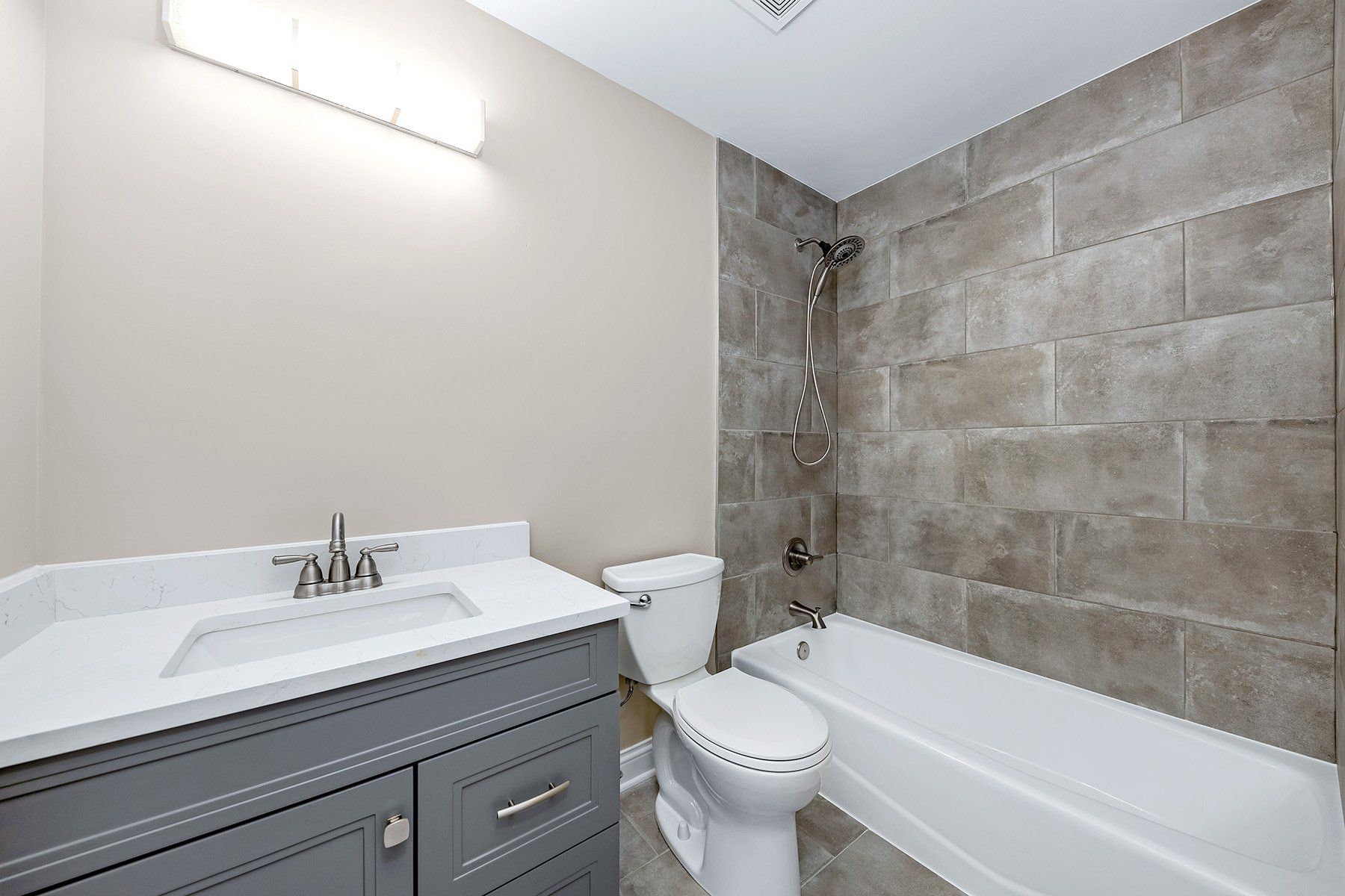 A bathroom with a toilet , sink and bathtub.