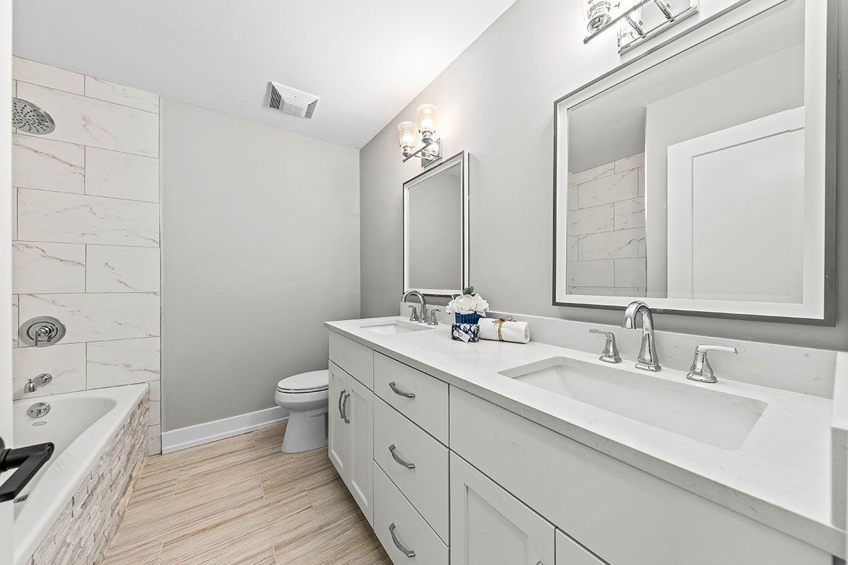 A bathroom with two sinks , a toilet , and a bathtub.