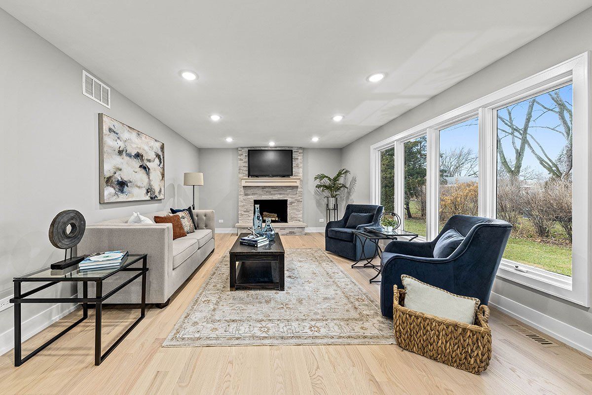 A living room with a couch , chairs , coffee table and fireplace.