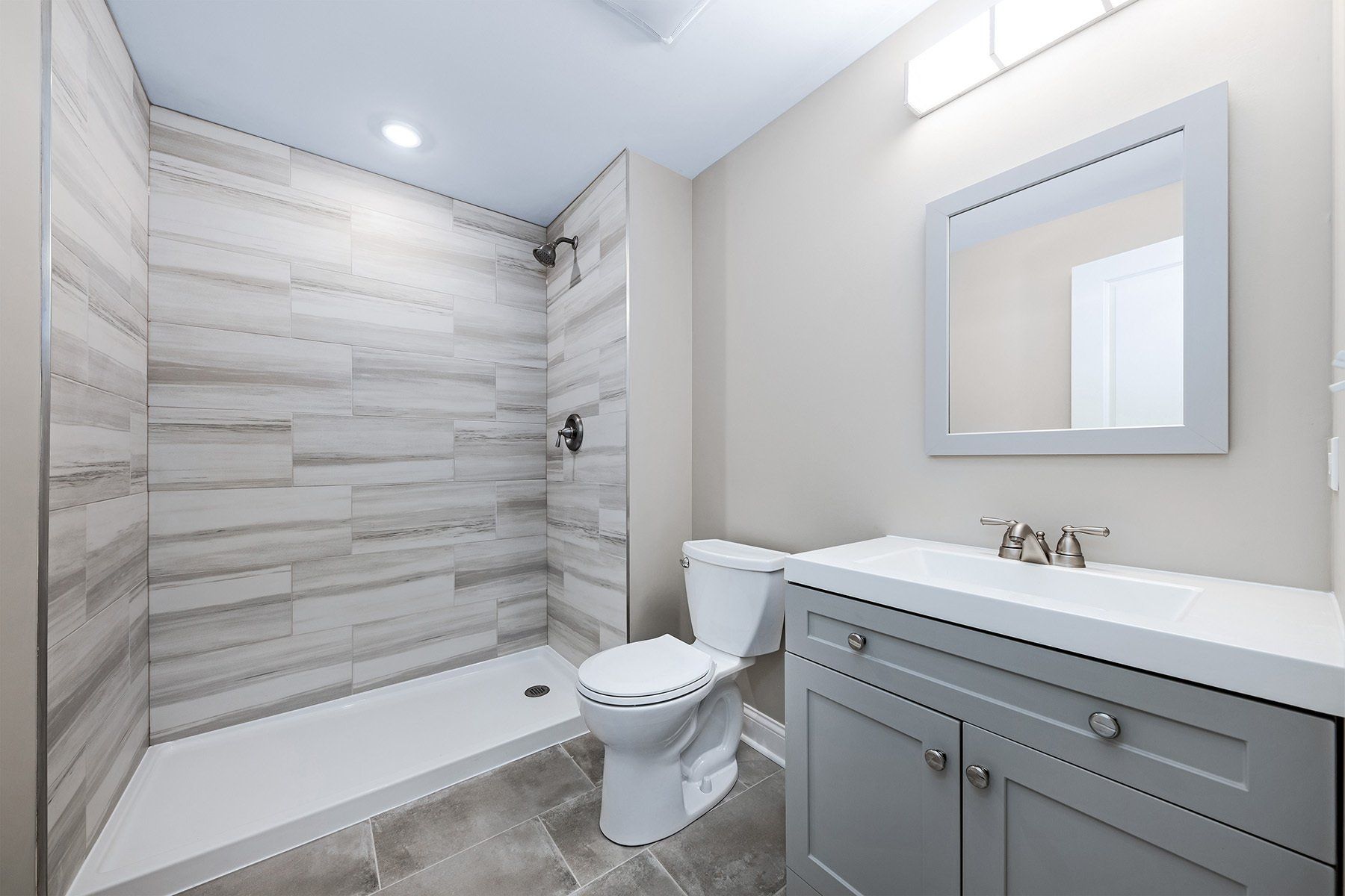 A bathroom with a toilet , sink and shower.