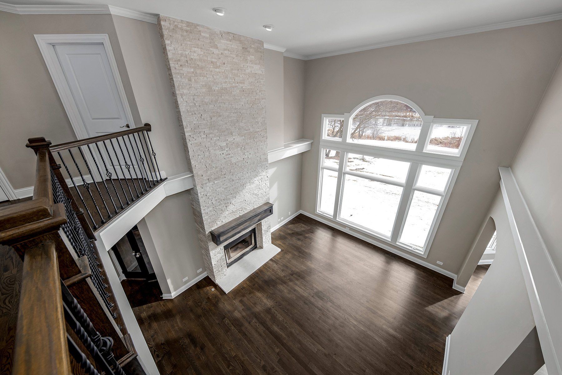 An aerial view of a living room with a fireplace and stairs.
