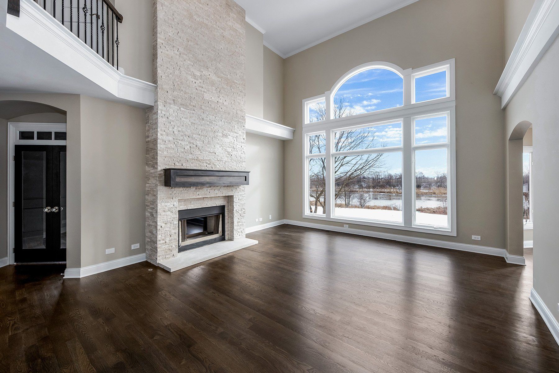 An empty living room with hardwood floors and a fireplace.