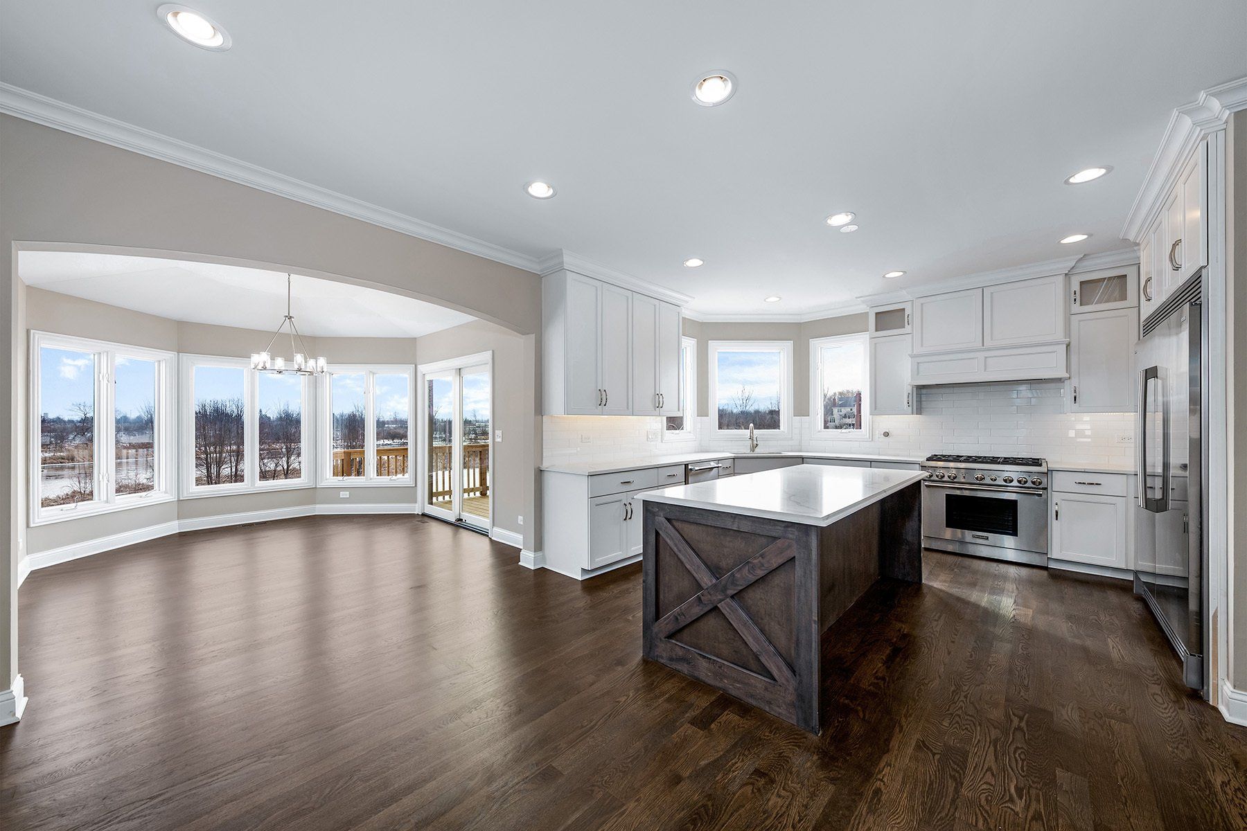 A large empty kitchen with stainless steel appliances and a large island.