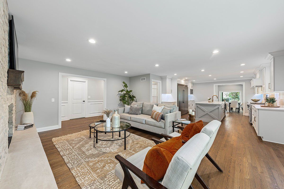 A living room with a couch , chairs , coffee table and fireplace.
