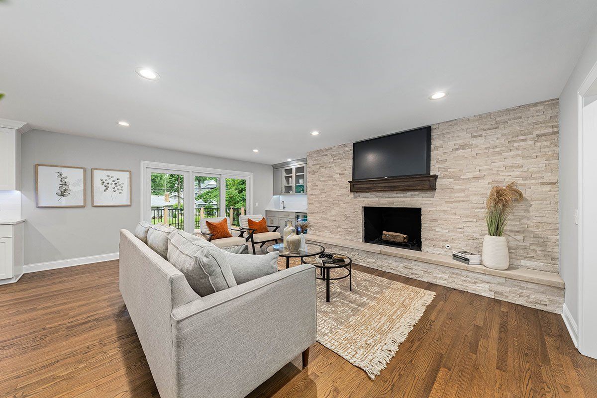 A living room with a couch , fireplace and television.