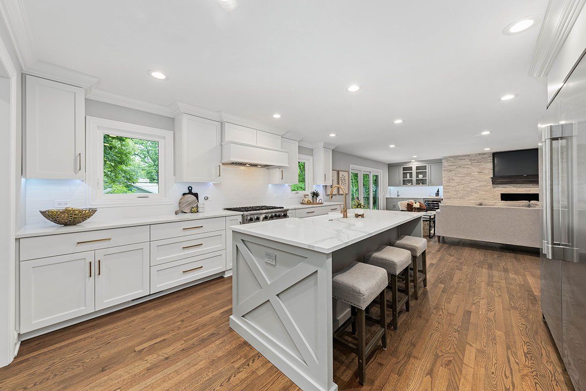 A kitchen with white cabinets and a large island in the middle.