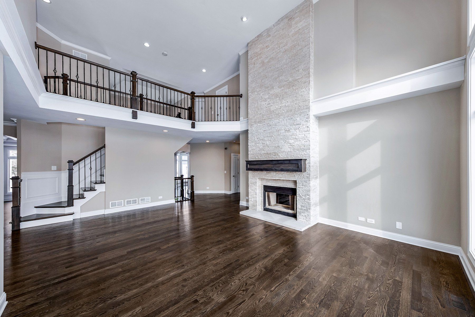 An empty living room with hardwood floors and a fireplace.