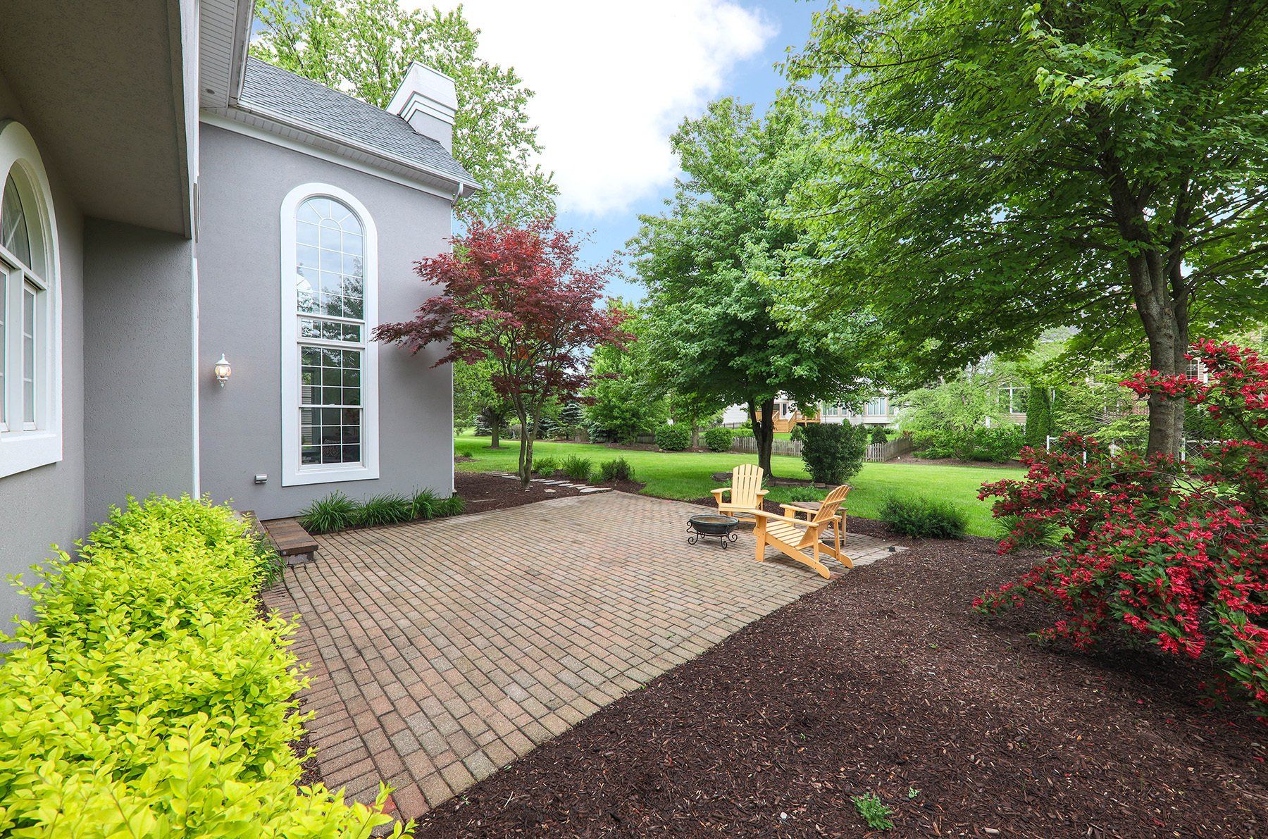 A house with a brick patio and a fire pit in the backyard