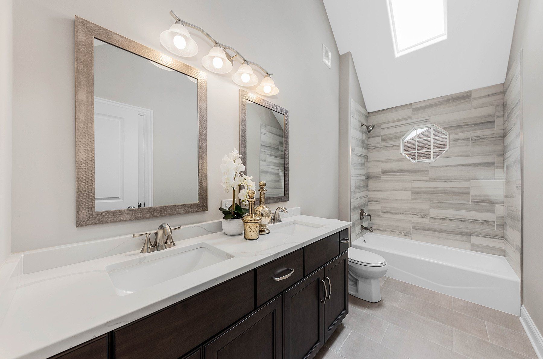 A bathroom with two sinks , a toilet , and a bathtub.