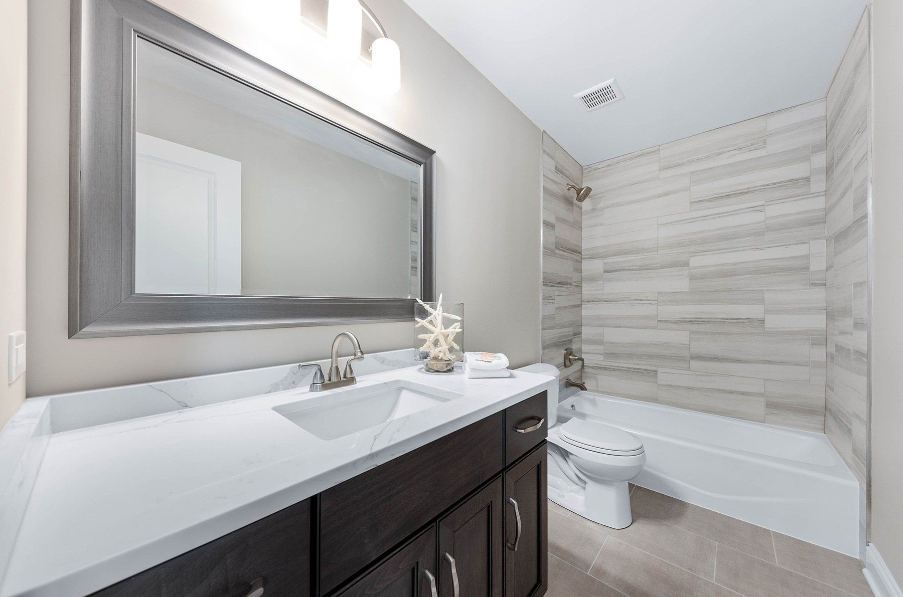 A bathroom with two sinks , a toilet , and a large mirror.