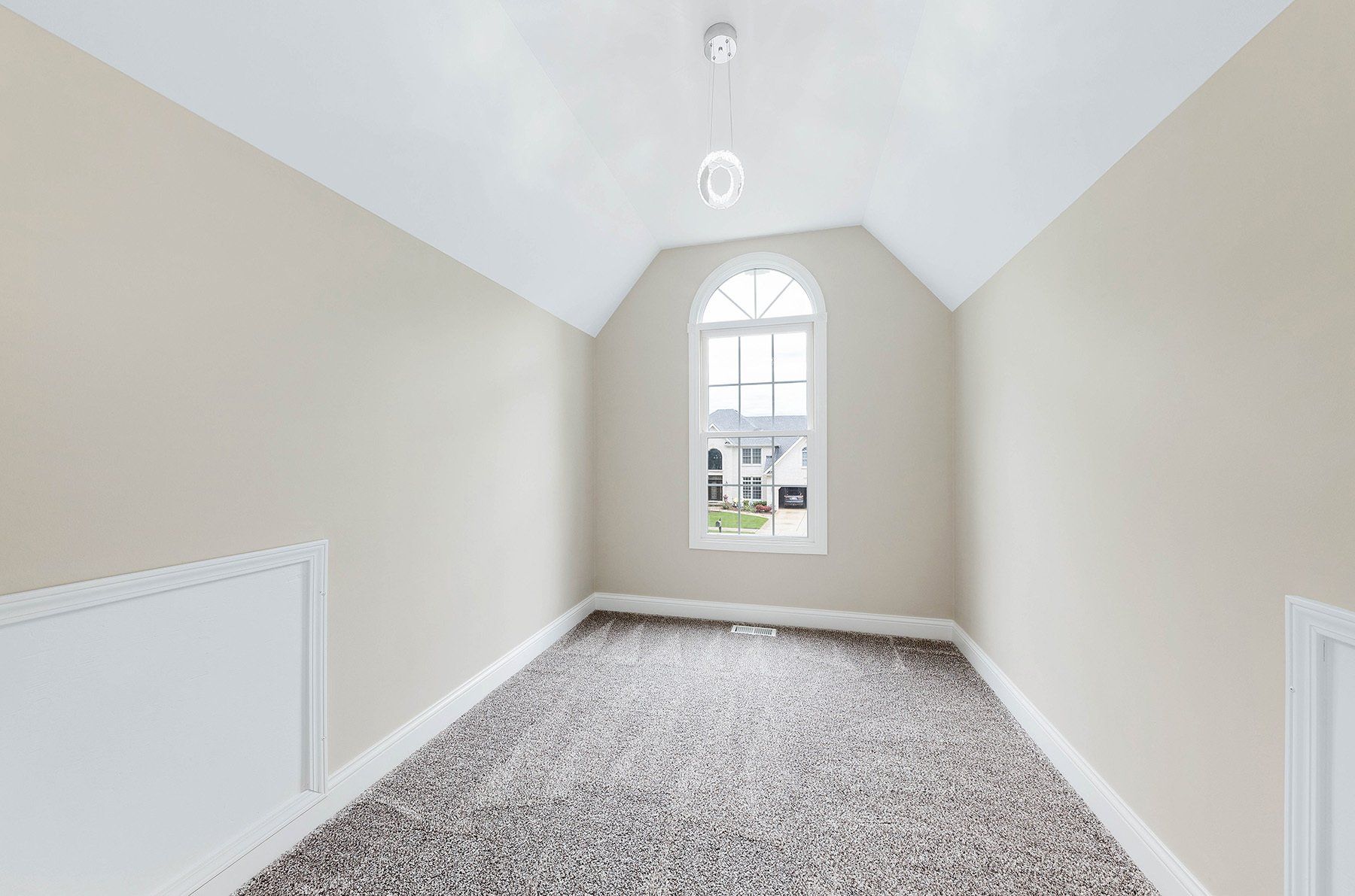 An empty room with a window and a carpeted floor.