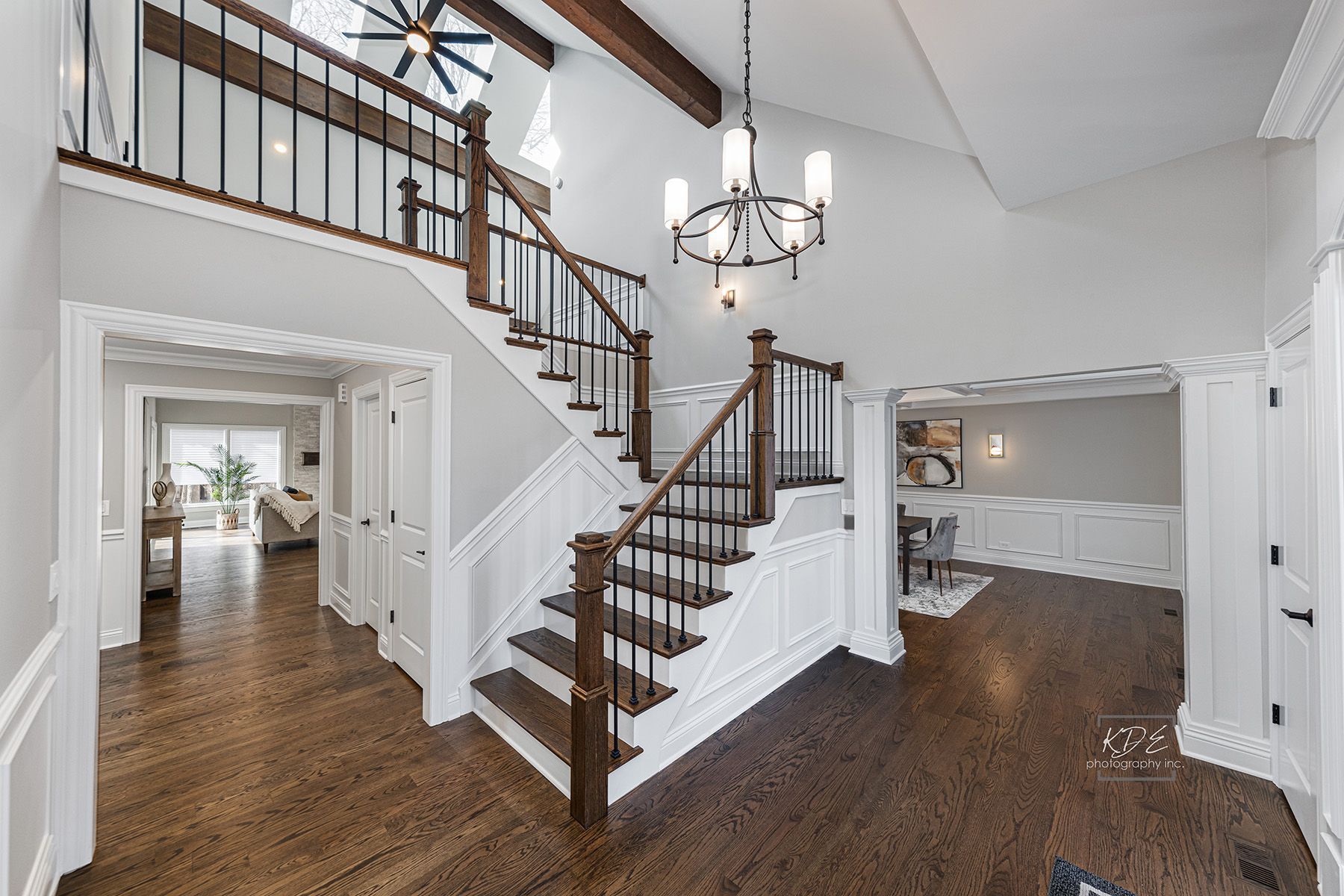 A large hallway with stairs leading up to the second floor of a house.
