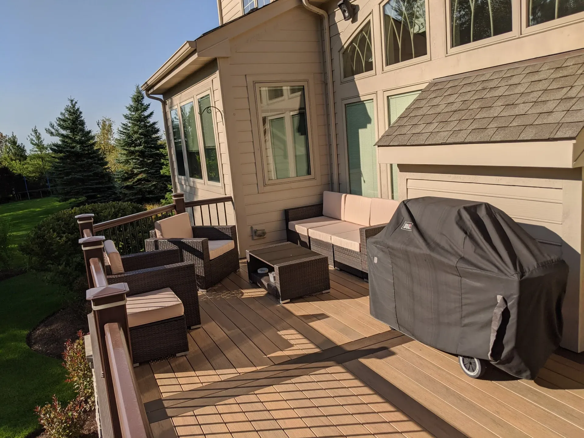 There is a grill on the deck of a house.