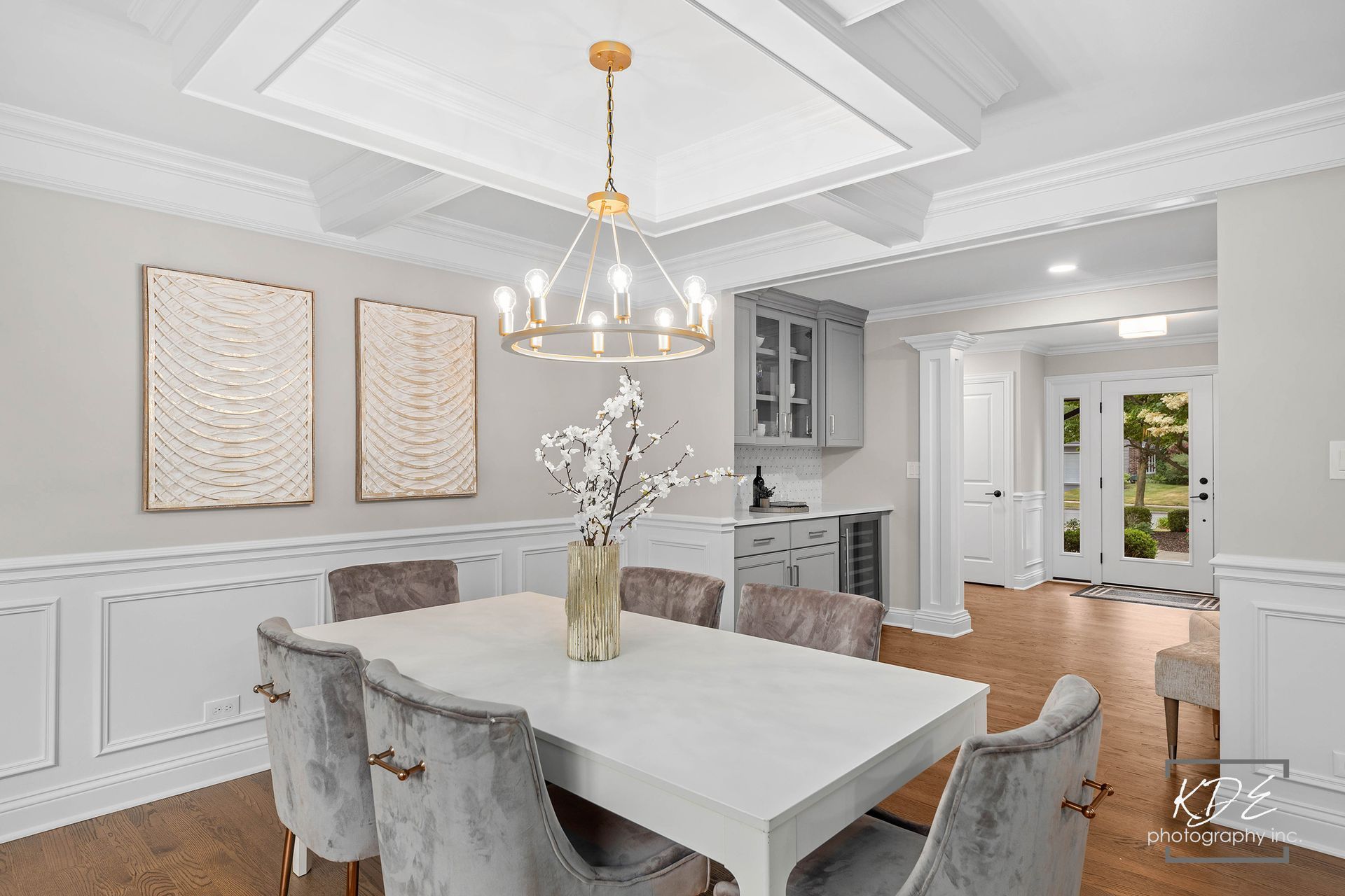 A dining room with a white table and chairs and a chandelier.