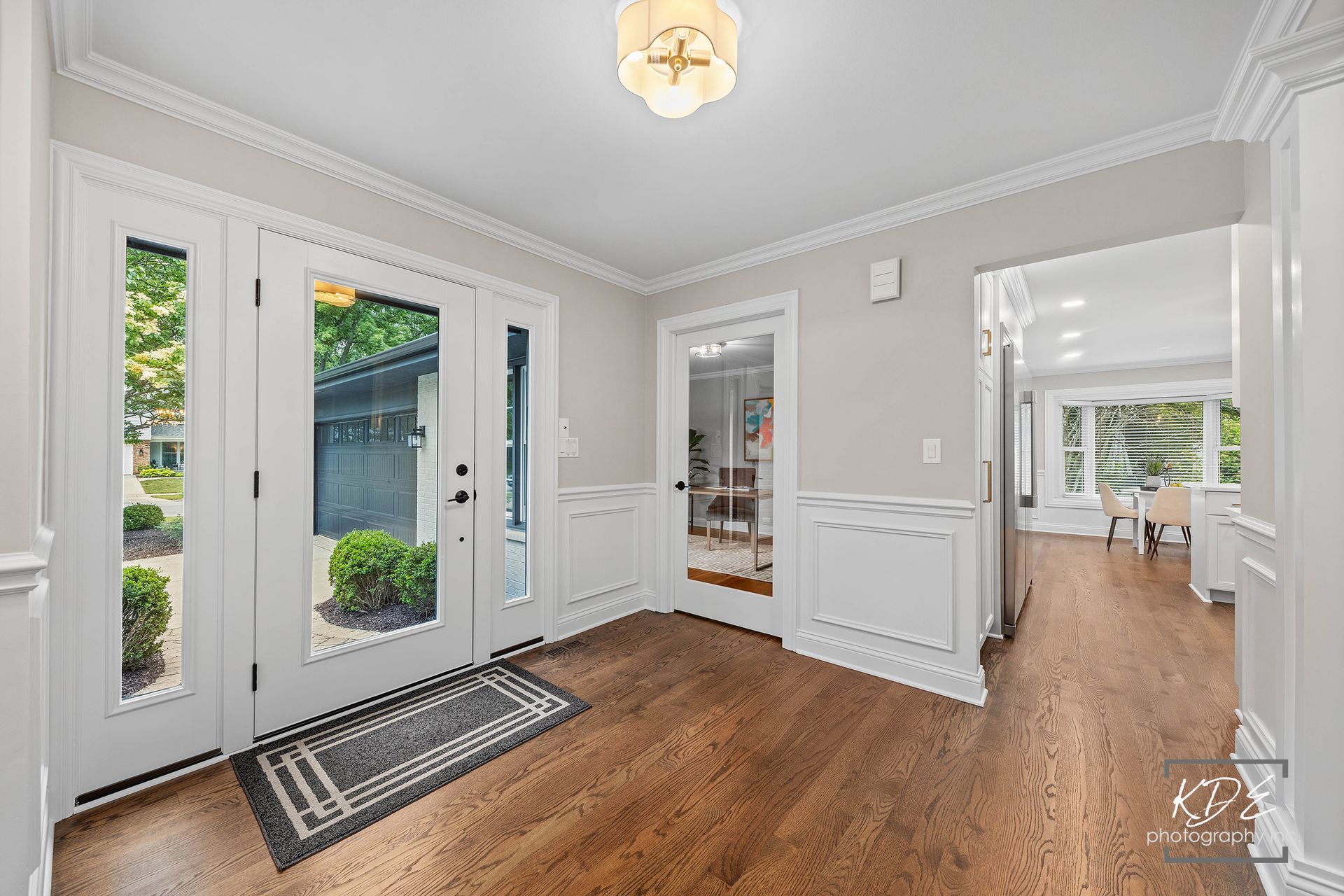A hallway in a house with hardwood floors and a white door.
