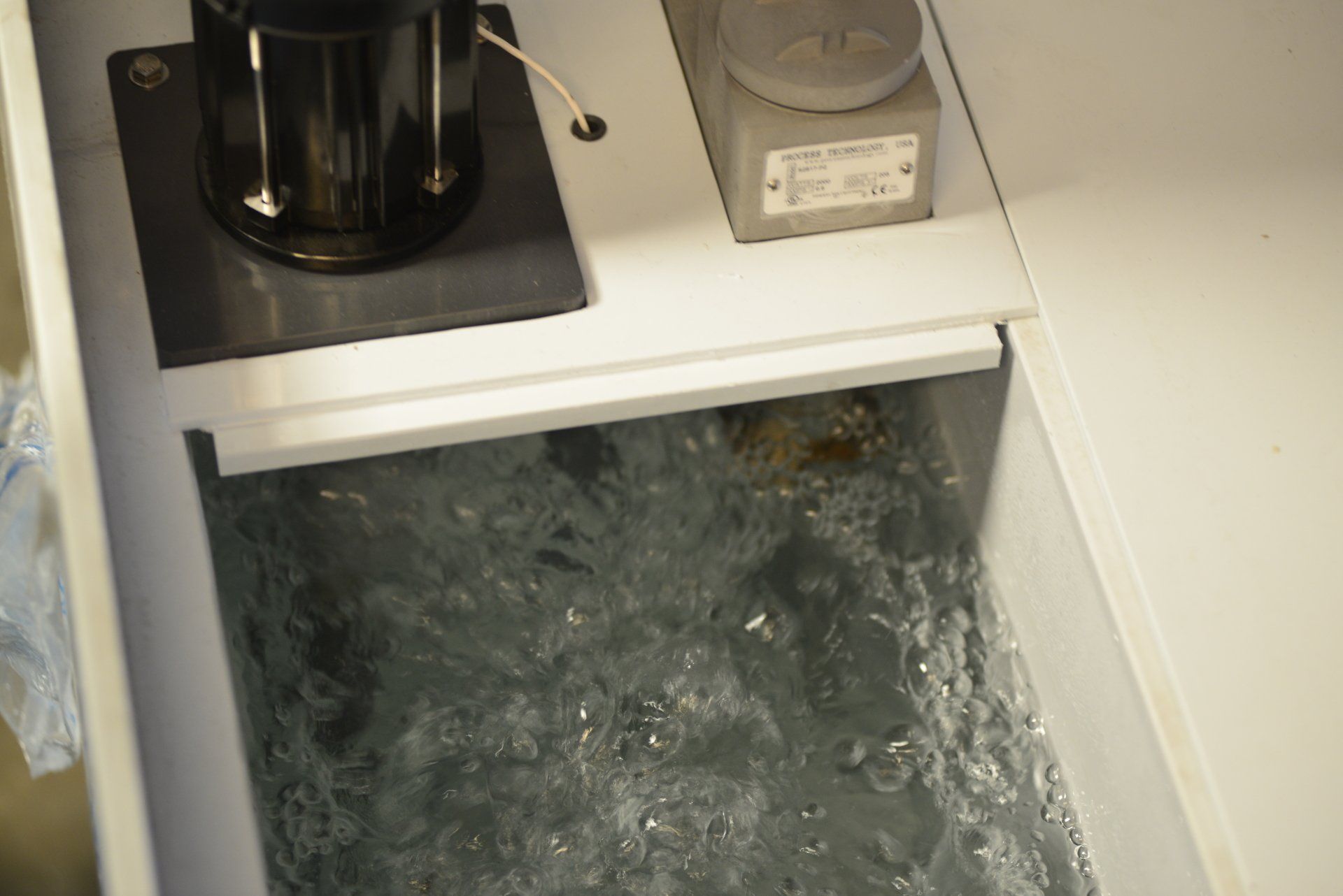 A sink with water coming out of it and a device on top of it