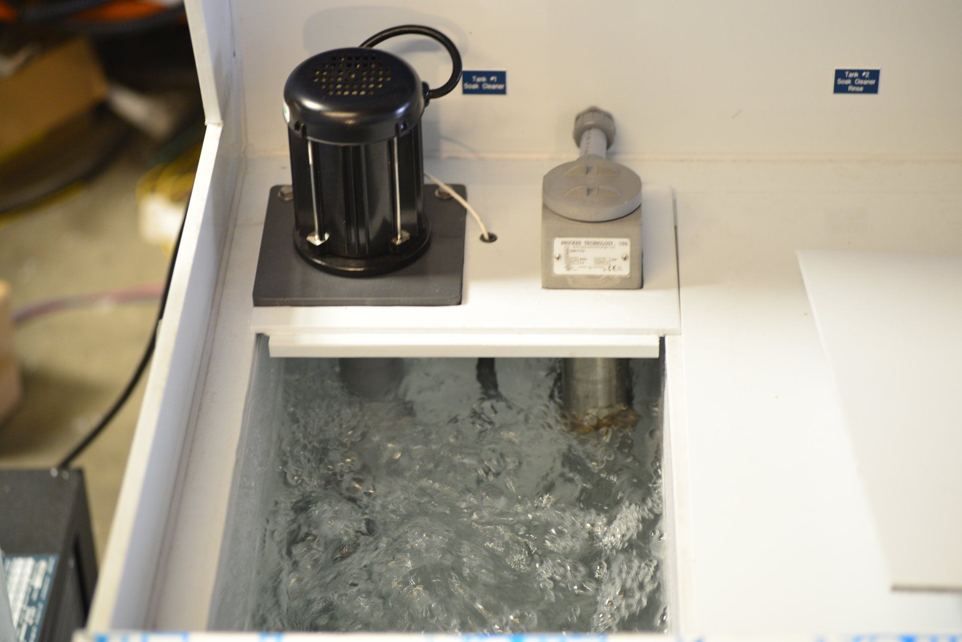 A machine with a black motor is sitting in a tank of water