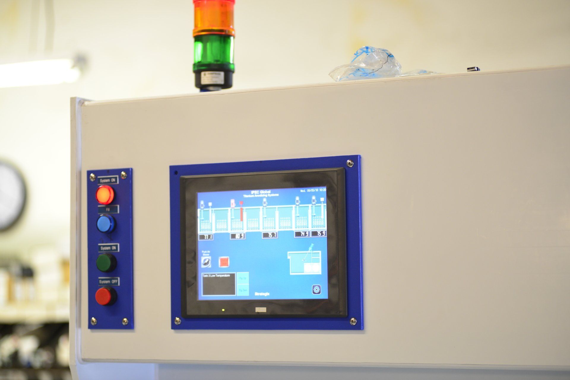 A close up of a touchscreen on a machine in a factory.