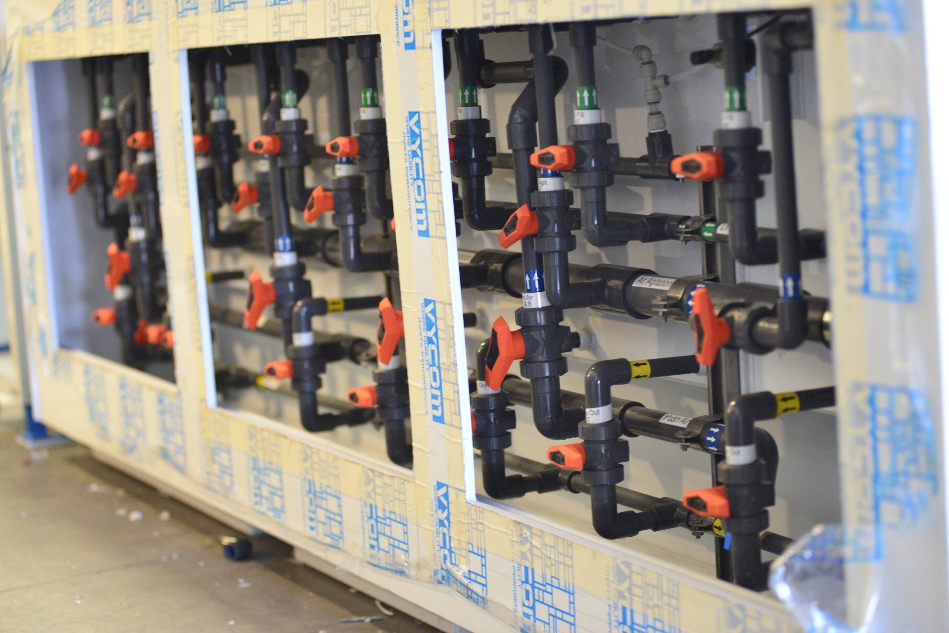 A row of pipes are lined up on a wall.