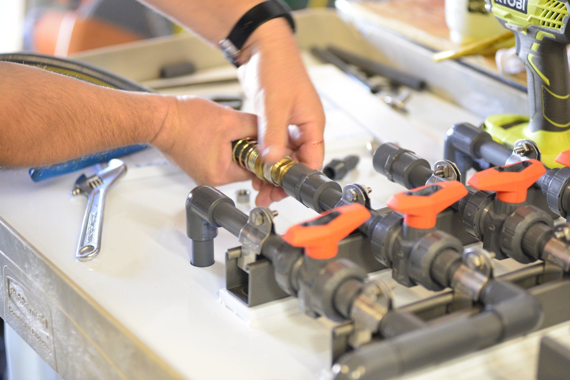 A person is working on a pipe on a table.