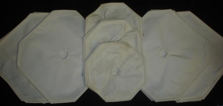 Three white napkins are stacked on top of each other on a black surface.