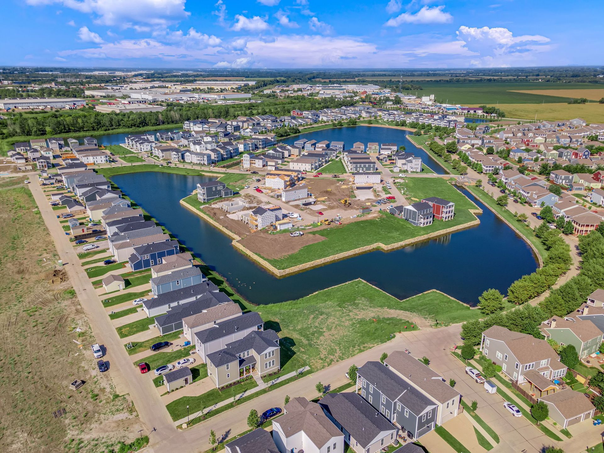 An aerial view of a residential area with a lake in the middle.
