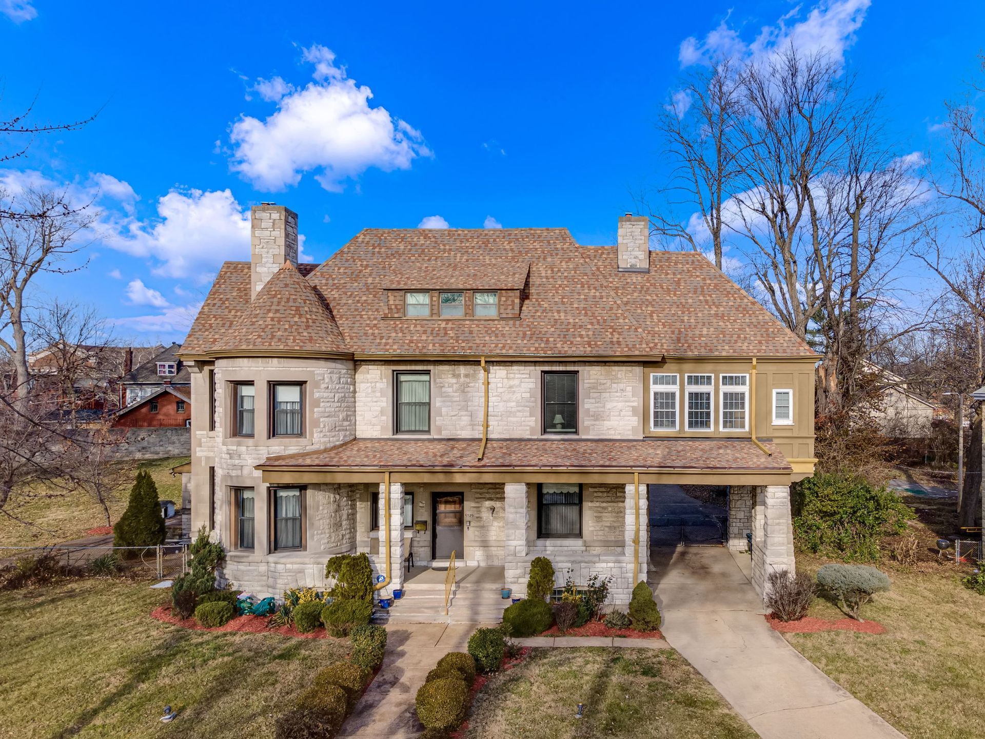An aerial view of a large house with a lot of windows on a sunny day.