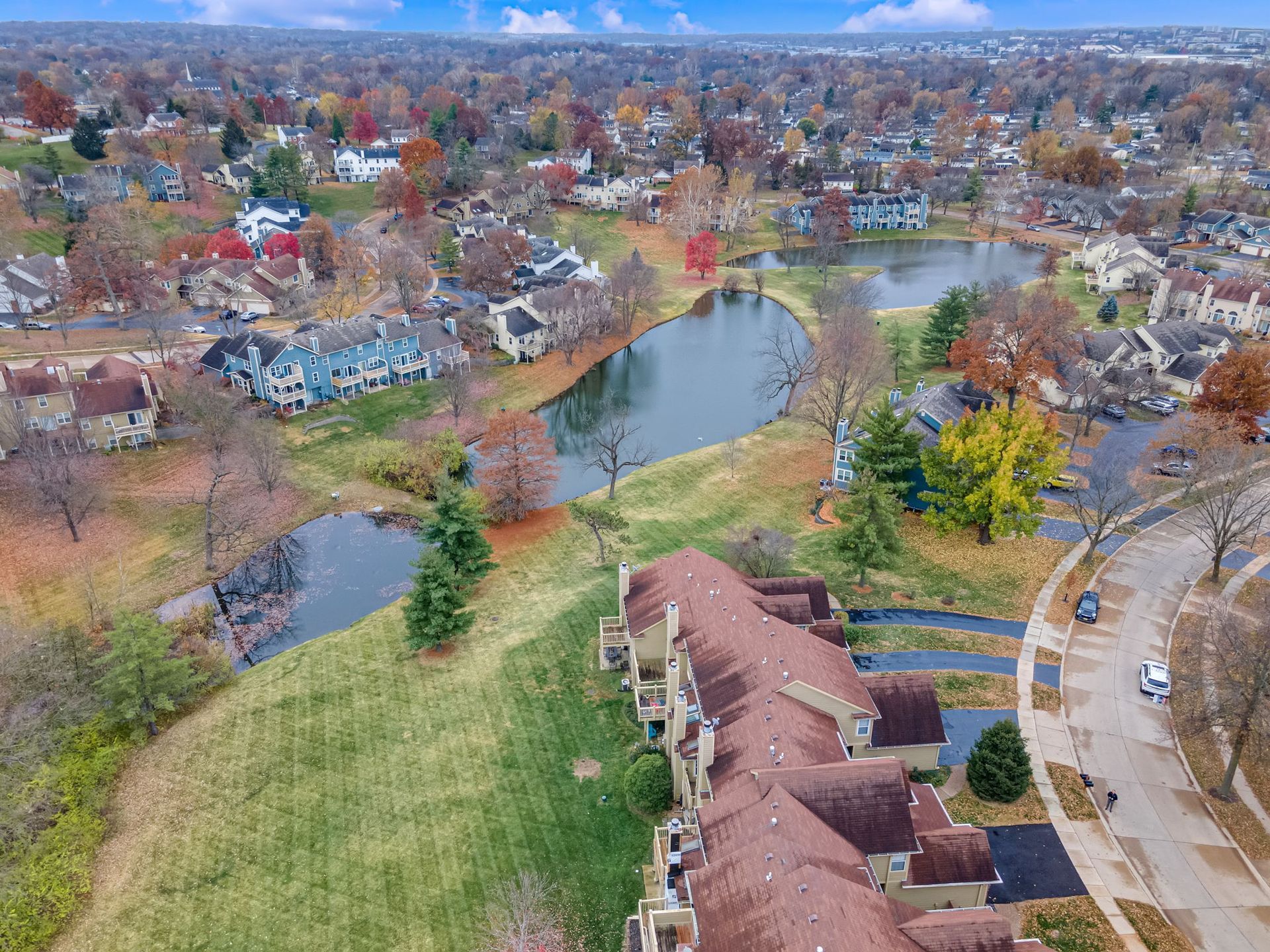 An aerial view of a residential area with a lake in the middle of it.
