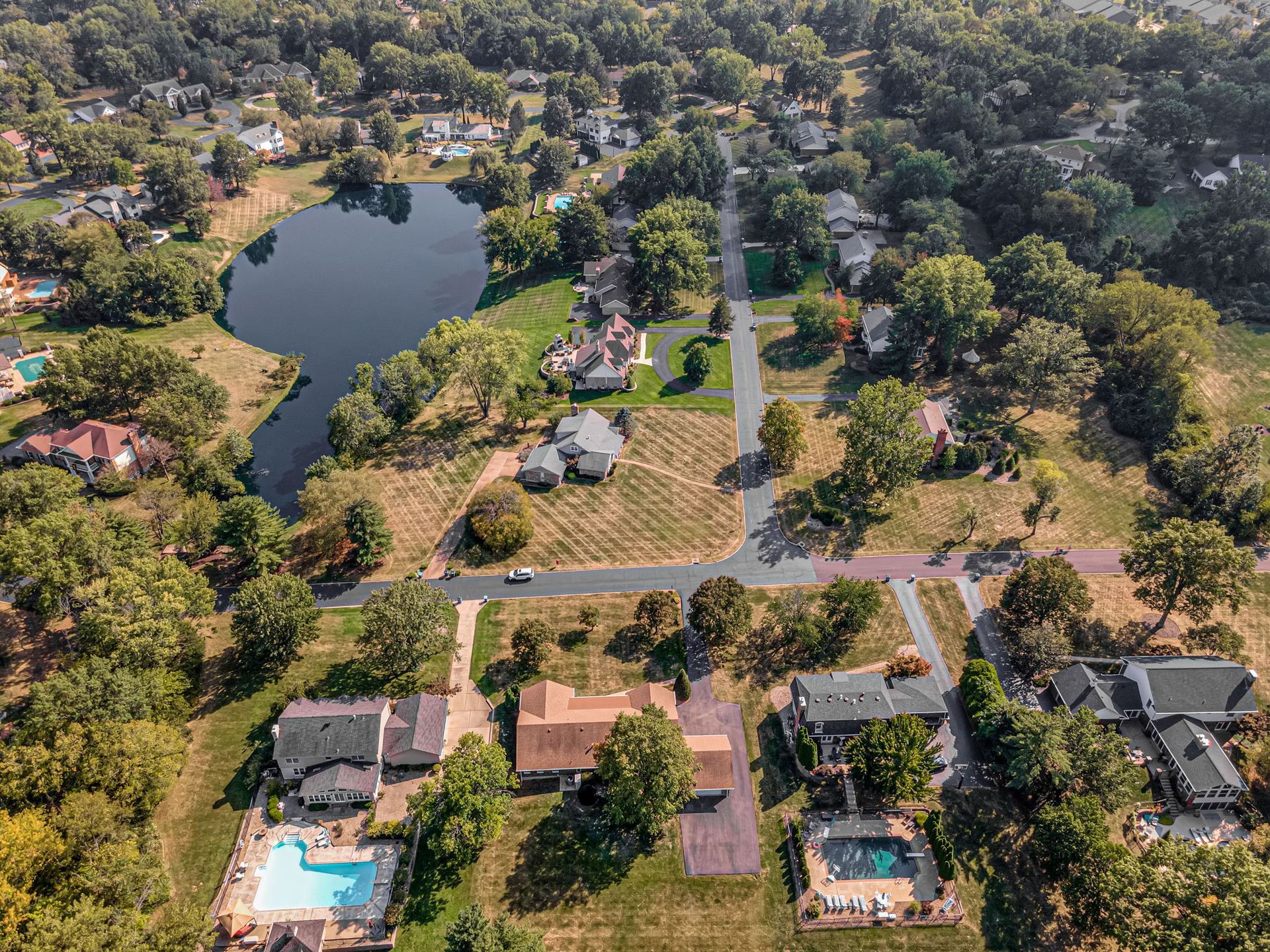 An aerial view of a residential area with a lake in the middle.
