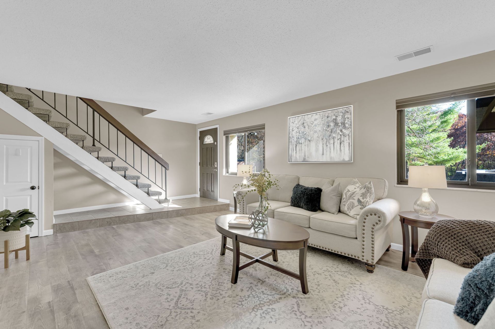 A living room with a couch , coffee table , and stairs.