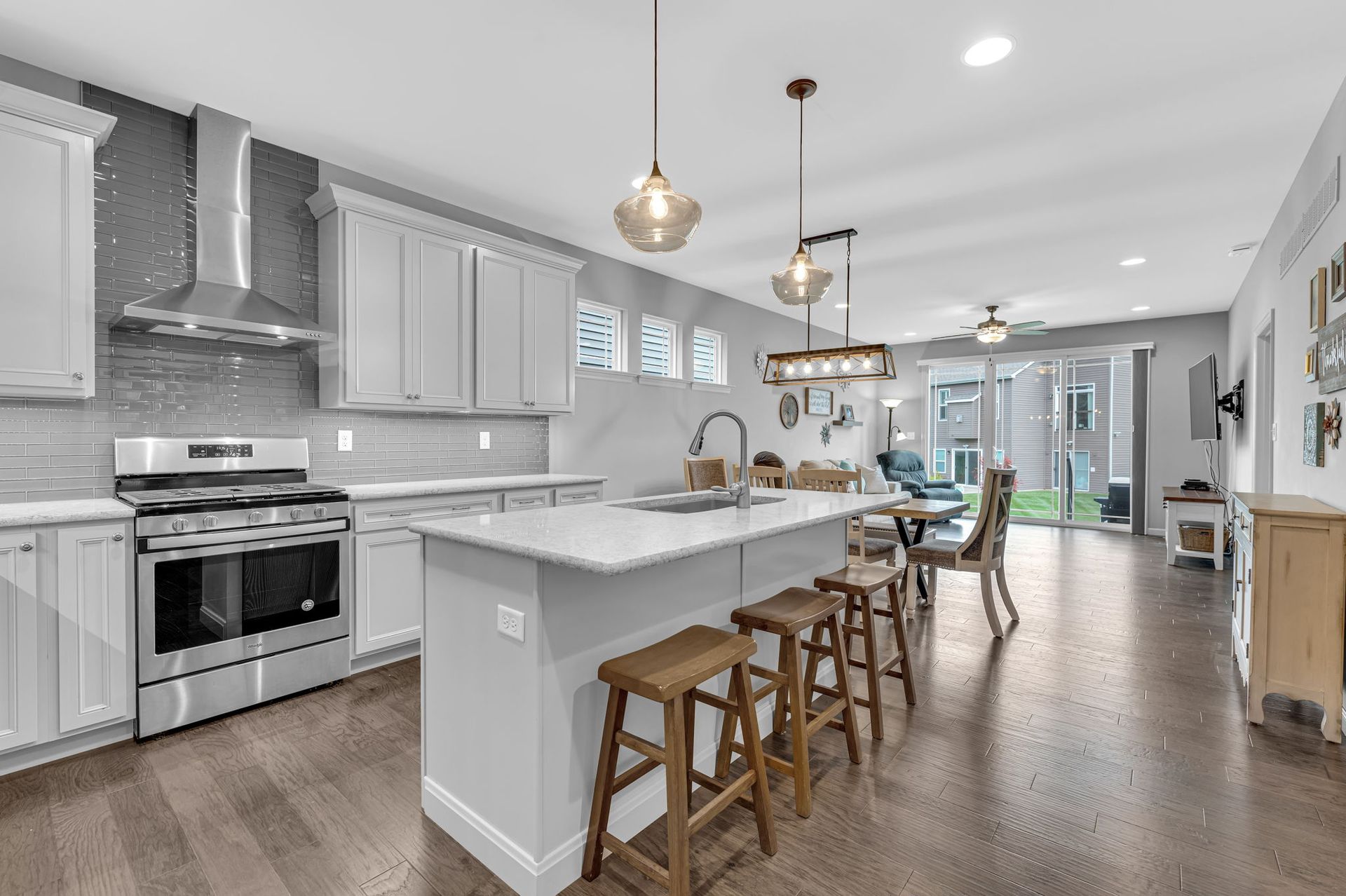 A kitchen with white cabinets , stainless steel appliances , and a large island.