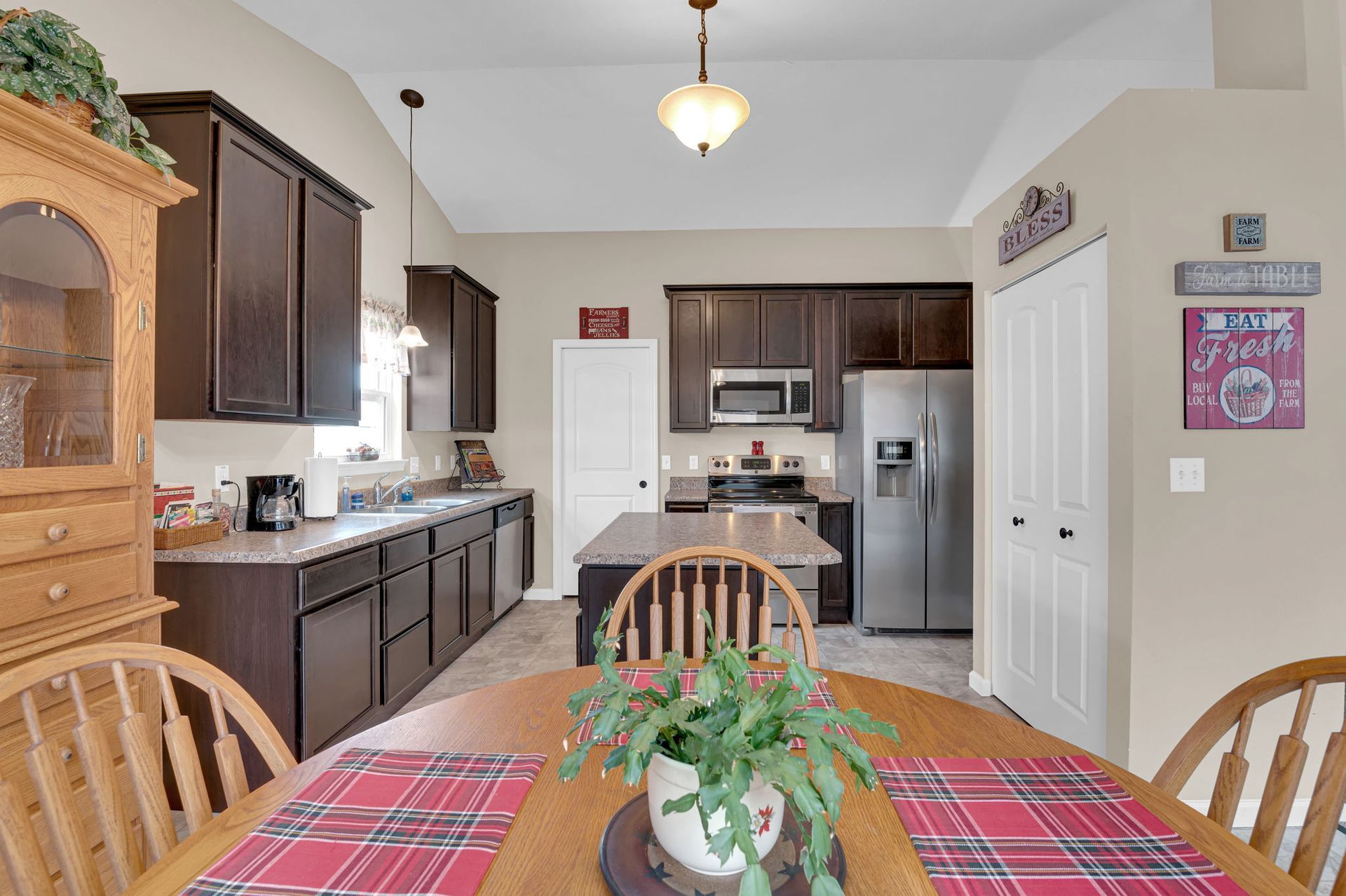A kitchen with a table and chairs and a potted plant on the table.