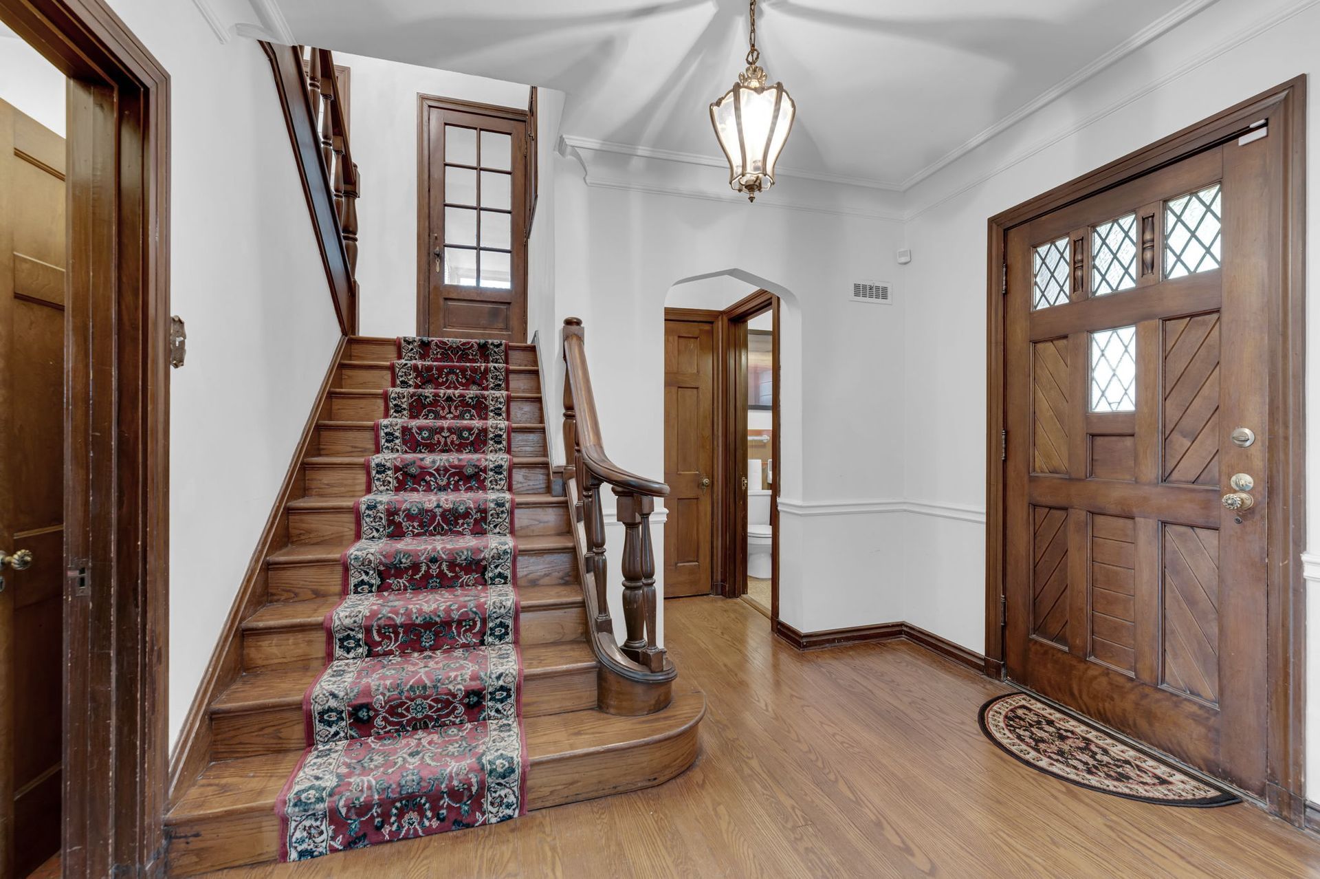 A hallway with stairs and a door in a house