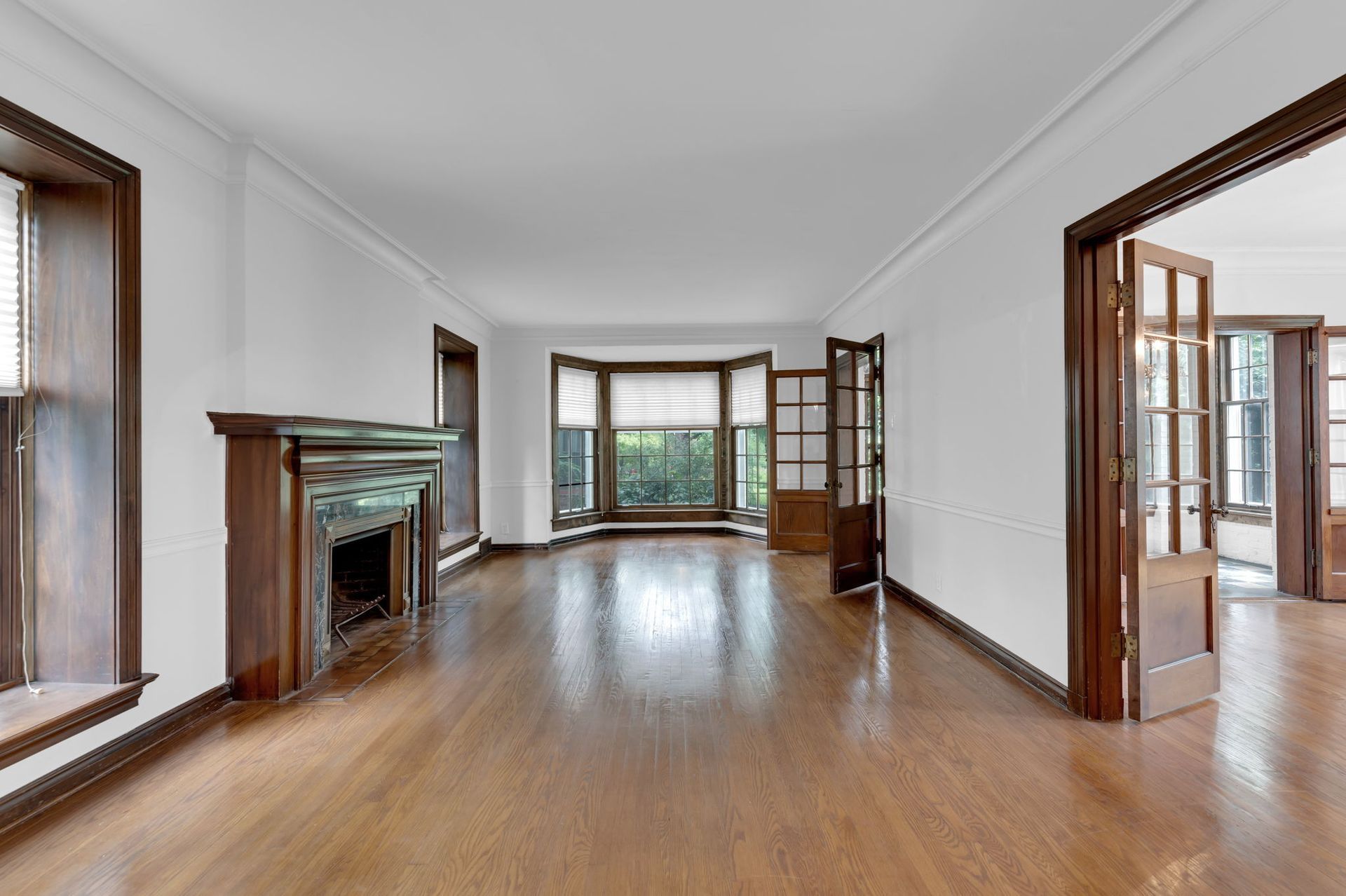 An empty living room with hardwood floors and a fireplace