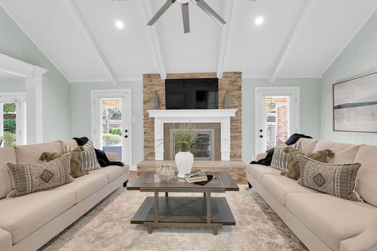 A living room with two couches , a coffee table , and a fireplace.