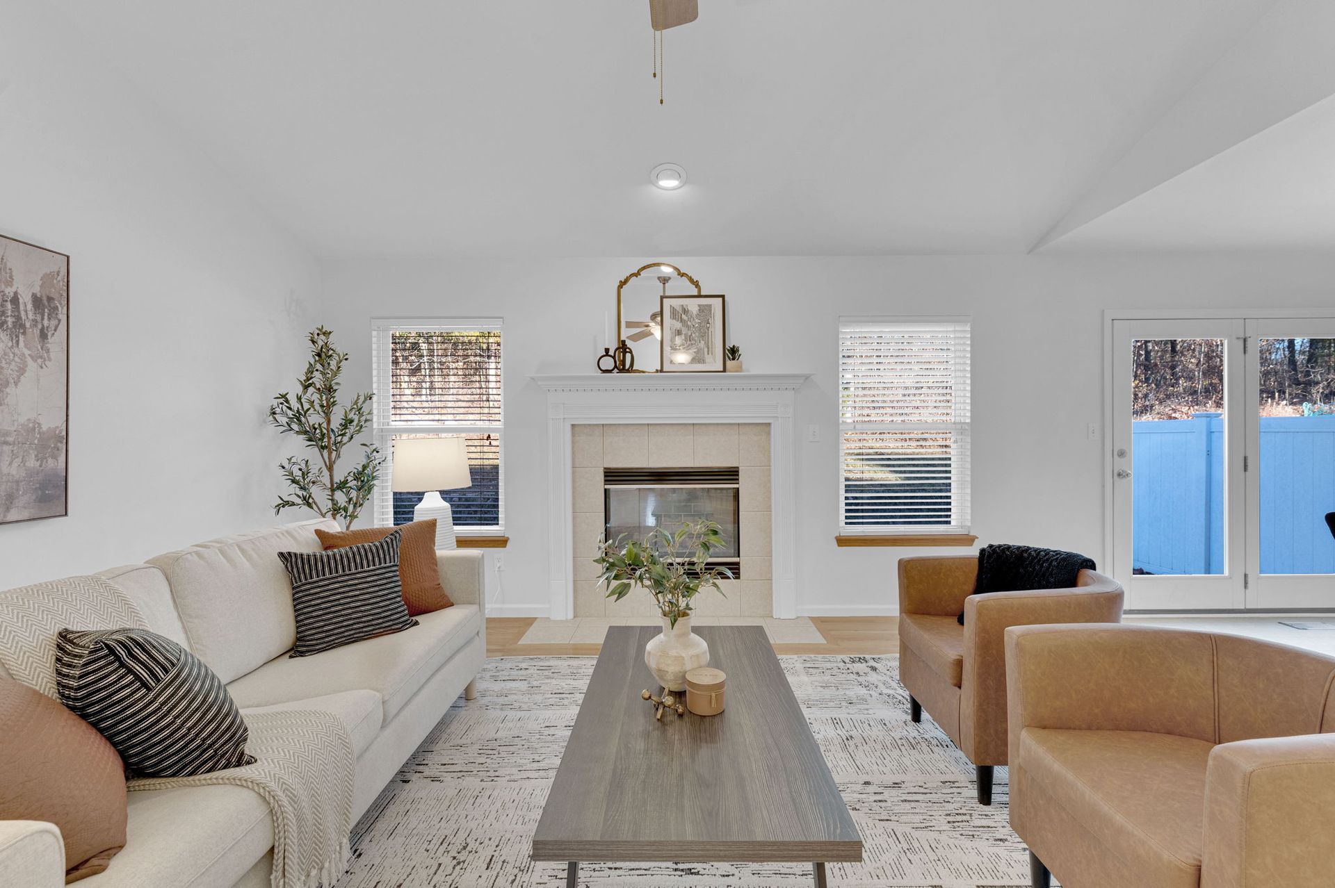A living room with a couch , chairs , coffee table and fireplace.