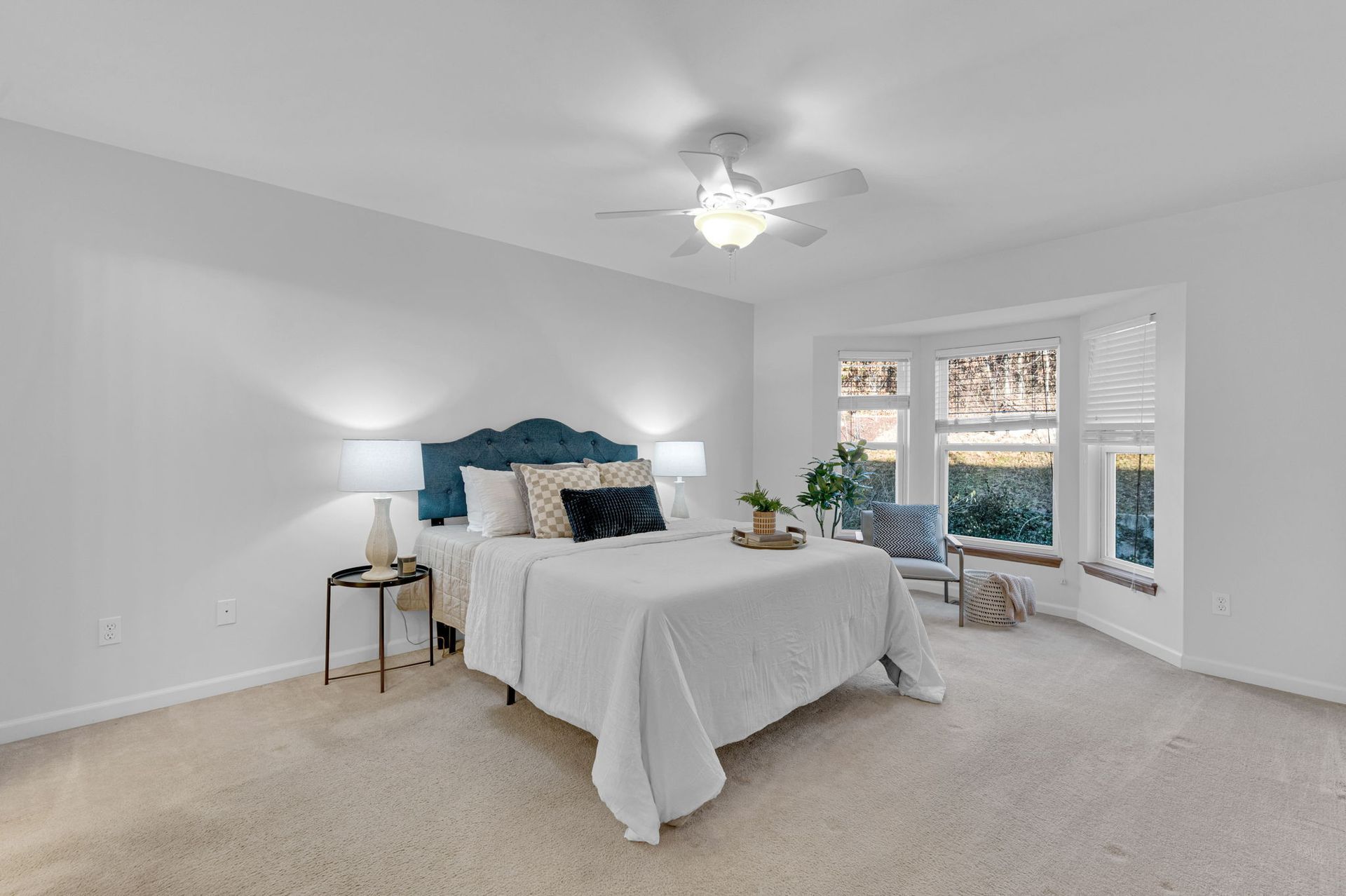 A bedroom with a large bed and a ceiling fan.