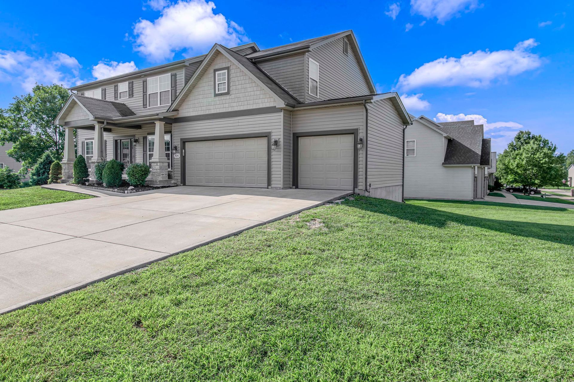 A large house with two garages and a driveway in front of it.
