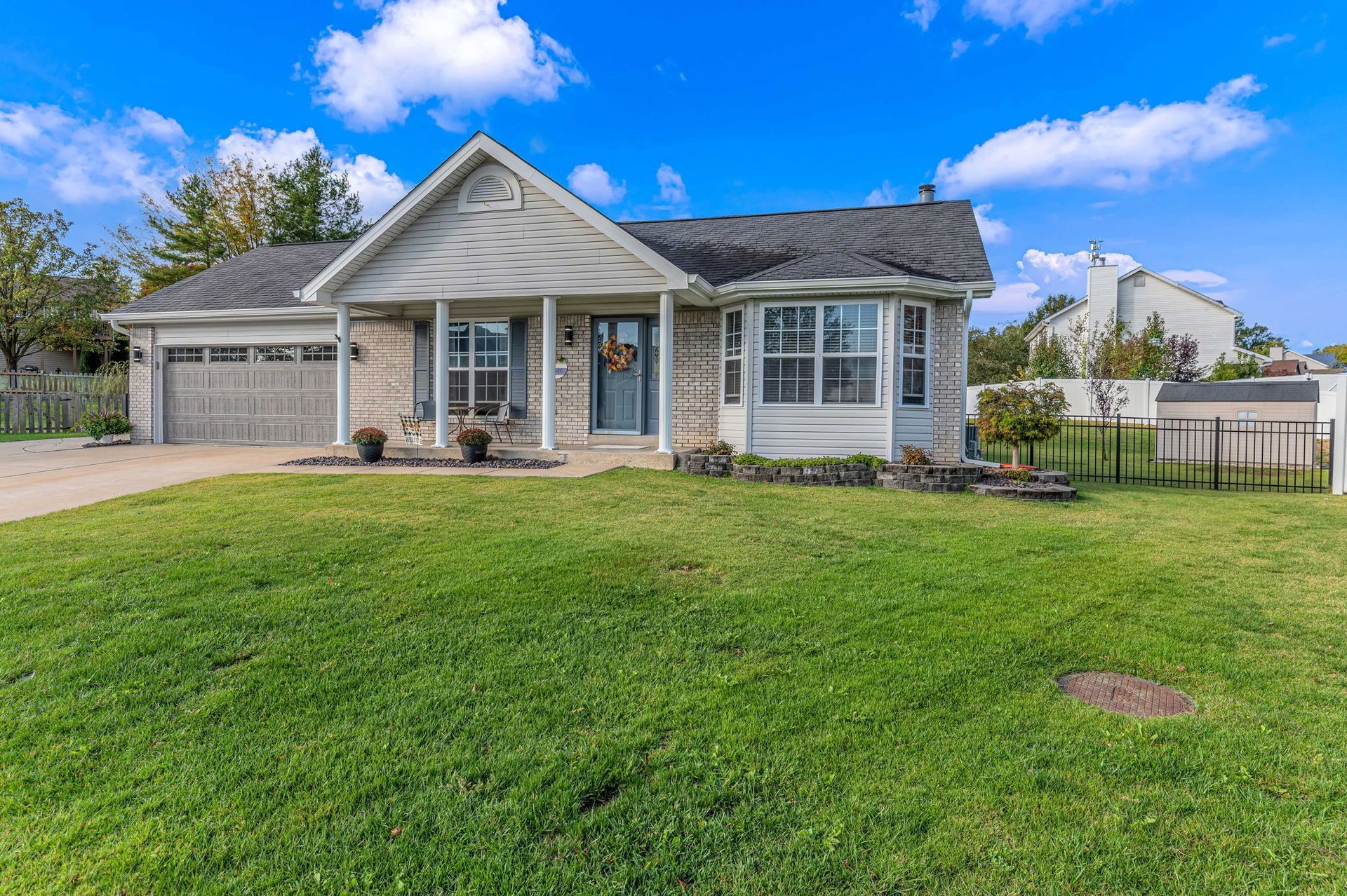 A white house with a large lawn in front of it.